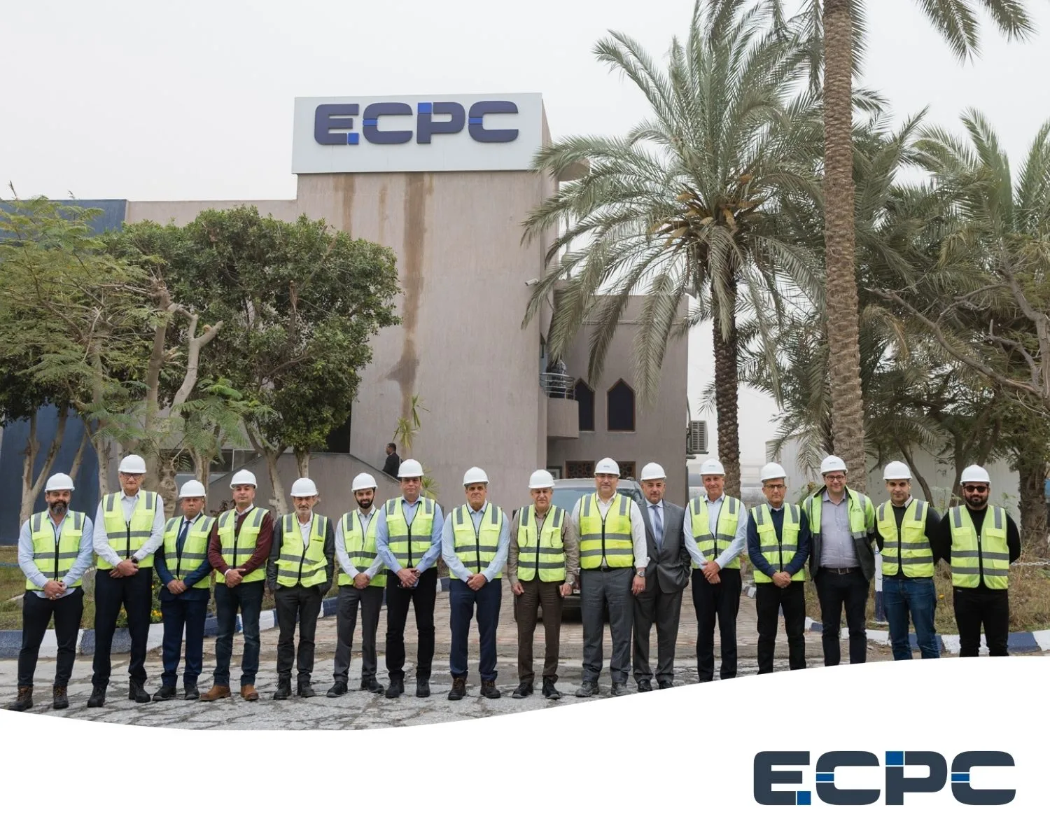 ECPC and SYMX executive teams standing together in safety vests and hard hats outside the ECPC headquarters during an infrastructure development visit.